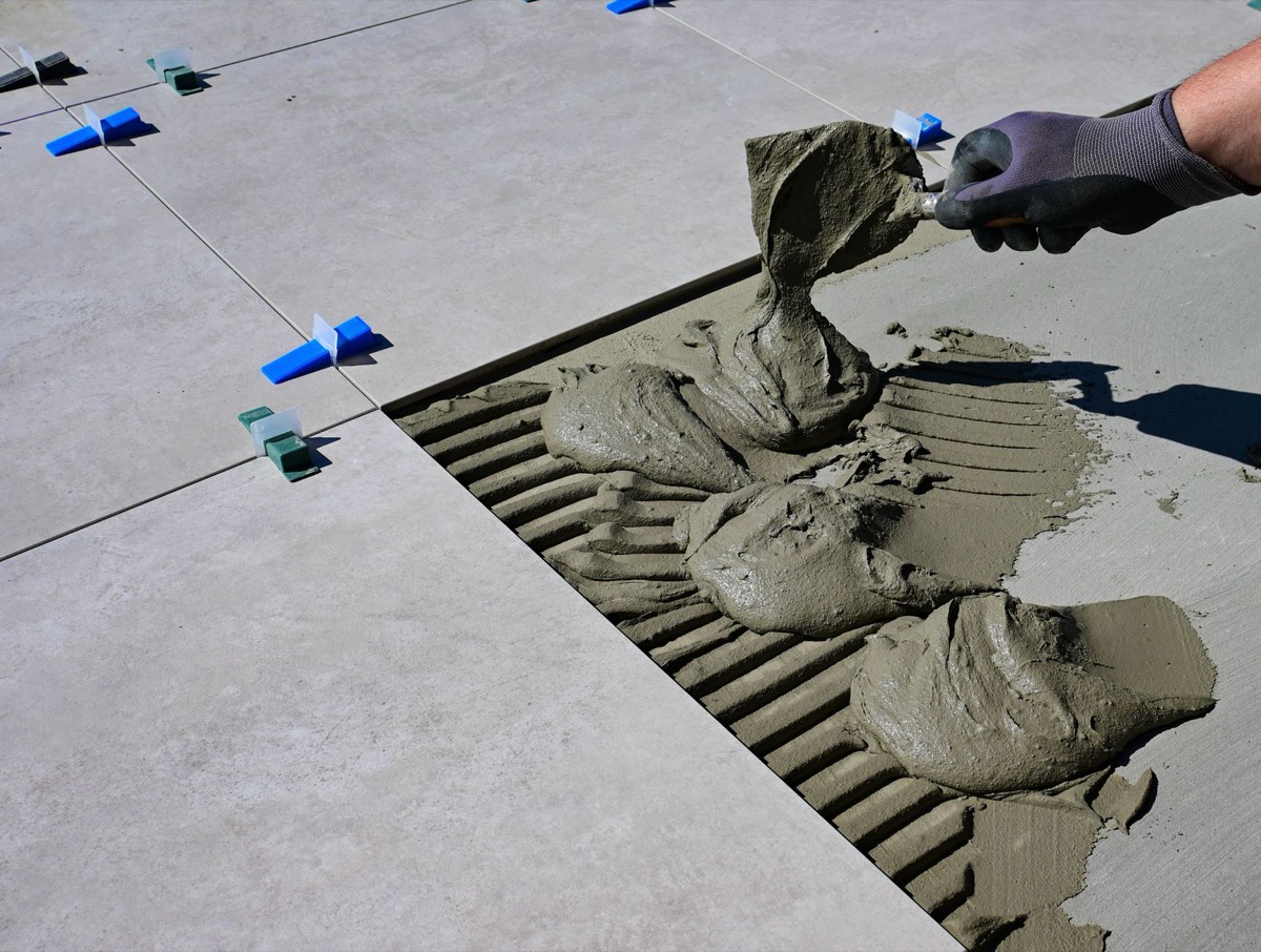 Tile installation materials including thinset, grout, notched trowel, spacers, and backer board